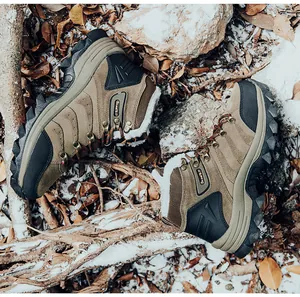 Detailed view of winter hiking boots with warm fleece lining on a snowy outdoor ground