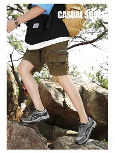Close-up of grey outdoor hiking shoes with mesh upper and reinforced heel on a rock