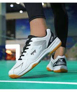 Dettaglio scarpe da badminton bianche con suola in gomma antiscivolo su campo indoor