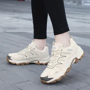 Outdoor shot of stylish beige hiking sneakers with mesh upper and durable lug soles