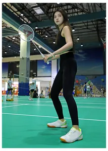 Dettaglio di scarpe da badminton bianche con accenti verde neon e suola in gomma gialla