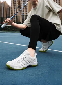 Detail view of white and green badminton shoes with mesh upper and non-slip sole