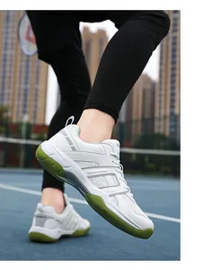 Detail of professional white court shoes with green rubber sole and mesh upper