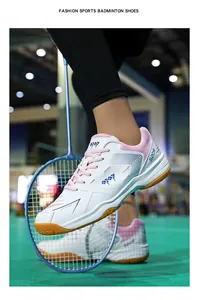 Dettaglio scarpe da badminton bianco rosa con logo S20W sul campo con racchetta
