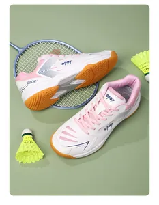 Vista dall'alto di scarpe da badminton bianche e rosa con rete e suola in gomma naturale