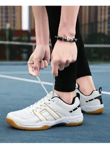 Close-up of athlete tying laces on white professional indoor sports shoes with rubber soles