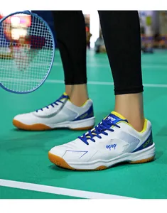 Dettaglio scarpe da badminton pro con suole in gomma antiscivolo sul campo verde