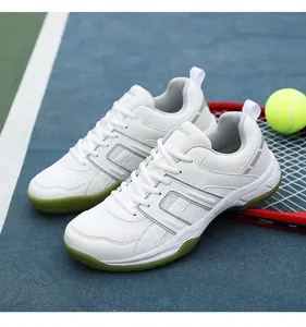 Detailed view of white athletic shoes with olive green sole on tennis court background