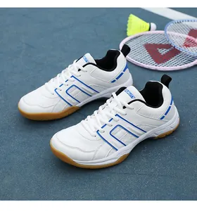 Detailed shot of white and blue court shoes on blue court with badminton equipment