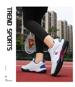 Nahaufnahme weißer Badmintonschuhe mit blau-violettem Logo auf einem roten Sportplatz
