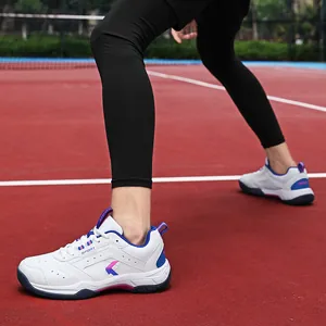 Weiße atmungsaktive Laufschuhe mit blau-rosa Farbverlauf-Logo auf dem Sportplatz