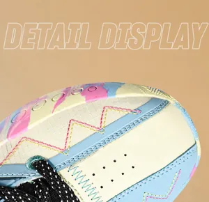 Detail view of colorful leather mesh sneakers with wavy yellow embroidery and dotted laces