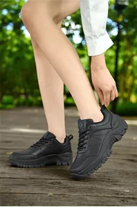 Close-up of black leather platform hiking shoes with anti-slip soles on wooden deck