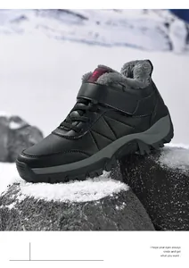 Bottes d'hiver noires imperméables avec doublure en fourrure sur rochers enneigés