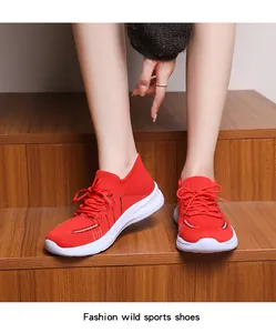 Dettaglio di sneakers rosse in mesh traspirante con suola platform su scale in legno