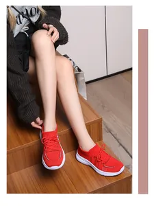 Vista delle sneaker rosse in maglia traspirante da donna su scale di legno