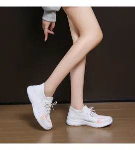 Vista laterale di sneakers bianche in mesh traspirante con strisce arancioni e plateau