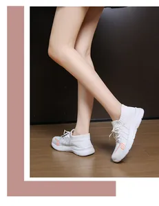 Dettaglio di sneaker platform in maglia bianca con strisce arancioni e suola in gomma