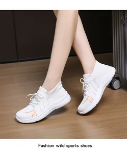 Vista indossata di sneakers in mesh traspirante bianche con dettagli arancioni e suola alta