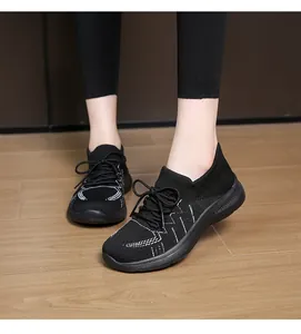 Dettaglio di scarpe sportive in maglia nera con texture geometrica e suola spessa