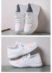 Dettaglio di sneakers in mesh bianco con accenti arancioni e suola spessa strutturata