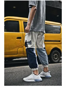 Detail of color-block cargo pants and white breathable sneakers in street style