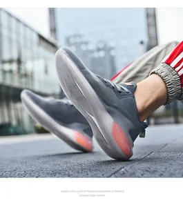 Macro shot of breathable grey mesh sneakers with orange cushioning accents on urban street