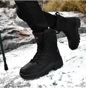Detail of waterproof black tactical boots featuring heavy-duty rubber soles on snowy rocks