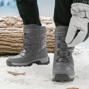 Grey waterproof winter snow boots with cross-lacing system on outdoor snowy background