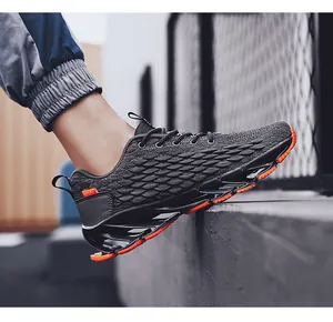 Detail of breathable knit sneakers with black blade sole and orange anti-slip accents