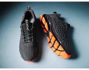 Detail of dark grey breathable mesh upper and vibrant orange segmented blade sole on sneakers