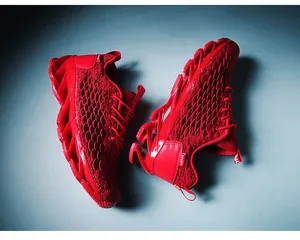 Macro view of bright red breathable mesh upper and blade cushioning sole on sport sneakers