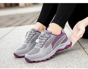 Detail of grey mesh walking shoes with purple accents and adjustable lace toggle