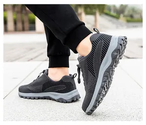 Detail of gray breathable knit sport shoe showing thick anti-slip rubber sole and elastic laces