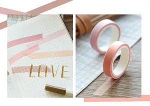 Macro detail of pink and orange washi tape applied on grid paper for DIY journaling