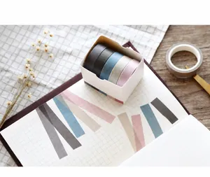 Close-up of five semi-transparent solid color washi tape rolls on a checkered journal