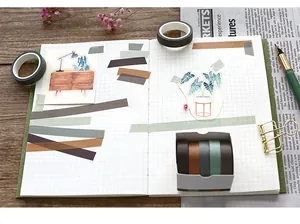 Flat lay of vintage style washi tape and stickers set on a grid notebook background