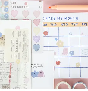 Close-up of summer themed heart stickers, monthly planner page and orange marker on pink