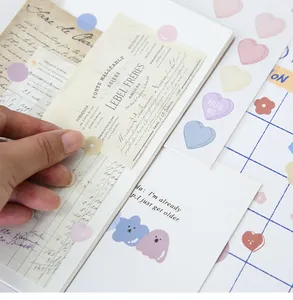 Detail of macaron heart and flower stickers applied on vintage journals and paper