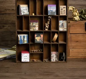 Detail of vintage junk journal paper blocks displayed in a rustic wooden organizer shelf