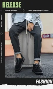 Fashionable all-black suede casual sneakers for men styled on a silver travel suitcase
