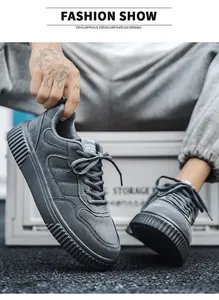 Detailed view of gray suede men sneakers featuring thick rubber soles and layered stitching