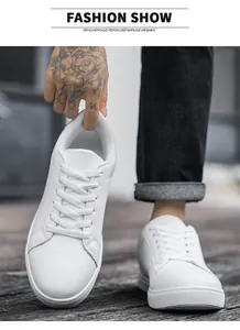 Detailed shot of white leather sneakers featuring thick rubber soles and flat laces