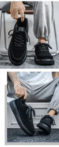 Detail shot of black low-top sneakers featuring thick rubber soles and suede texture