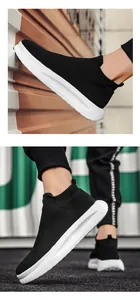 Detail of black breathable knit upper and white thick cushioning sole on men's sock sneaker