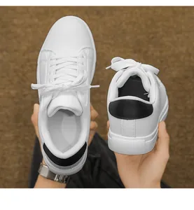 Detail shot of white casual sneakers with black leather heel accent and soft leather texture