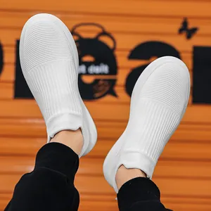 White knit slip-on sneakers for men with breathable mesh and thick soft soles on orange background