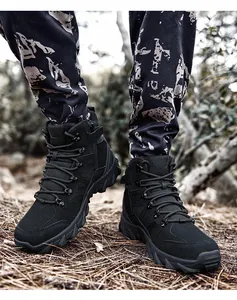 Detail view of black tactical boots with side zipper and rugged rubber outsole on forest ground