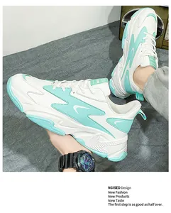 Detail view of white and mint green chunky sneakers with layered mesh and thick soles