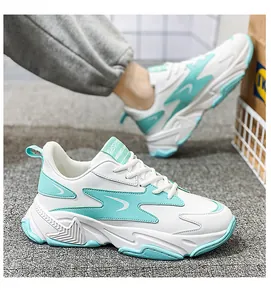 Close-up of white and mint green chunky sneakers with breathable leather mesh details
